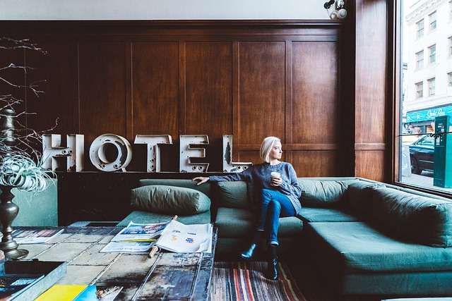 Hotel Signs - Woman sitting on a couch in front of a hotel sign